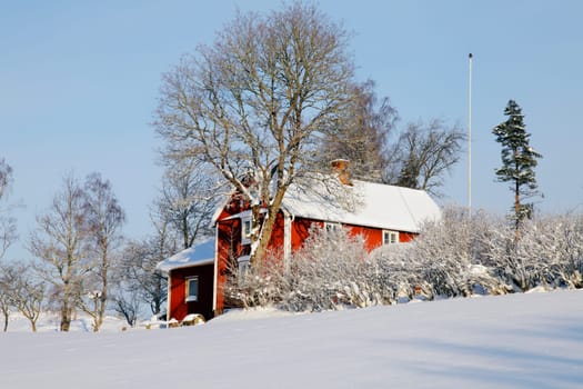 old red farm in winter-time, snowy landscape from sweden