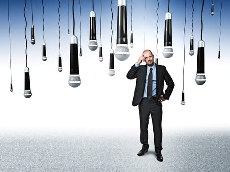 standing businessman and lots of microphone