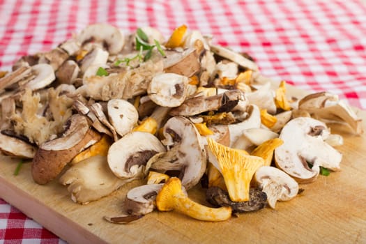 Mixed fresh mushrooms,cut on a wooden board