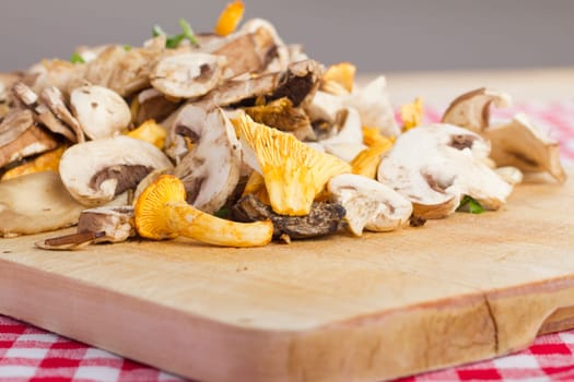 Mixed fresh mushrooms,cut on a wooden board