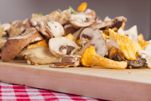Mixed fresh mushrooms,cut on a wooden board