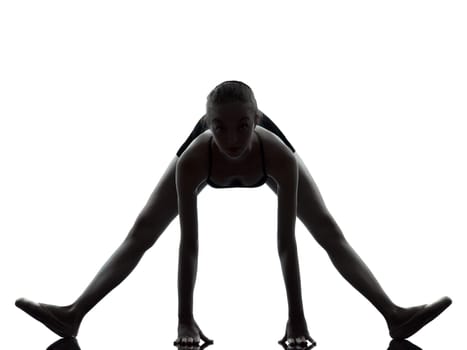 one caucasian young woman ballerina ballet dancer stretching warming up in silhouette studio on white background