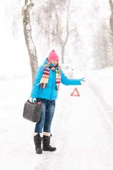 Woman hitchhiking on road snow gas can car breakdown problem