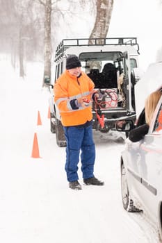 Man helping woman with broken car snow assistance winter mechanic