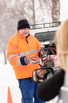 Man help woman broken car starting cables snow assistance winter