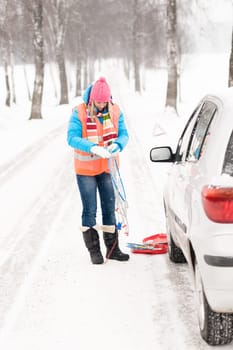 Woman holding tire chains car snow broken problems winter young