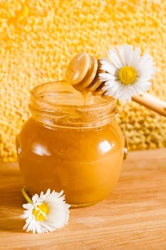 jar of honey on the background of honeycombs