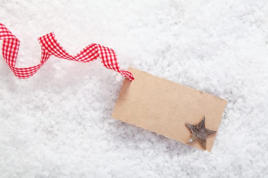 Empty place card or gift card for christmas and festive winter concepts. On white snow background.