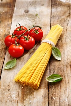 Spaghetti and tomatoes with copyspace on a wood background