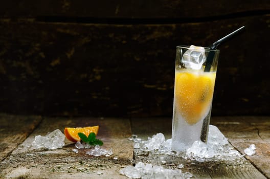 Alcohol Orange Shot Drink with copyspace, on brown wooden board.