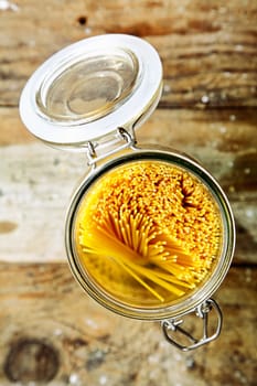 Overhead view of a kitchen container full of Italian spaghetti pasta for use as an ingredient in Mediterranean cuisine