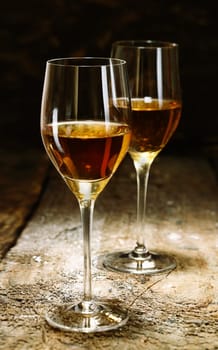 Two glasses of sherry on brown wooden background