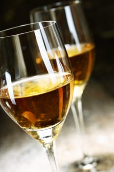 Two glasses of sherry on brown wooden background