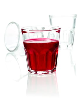 Glass of red rum cocktail blended with fruit juice and soda on a white studio background with copyspace