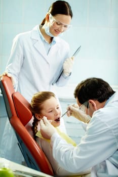 Young patient undergoing usual check-up procedure at dentists