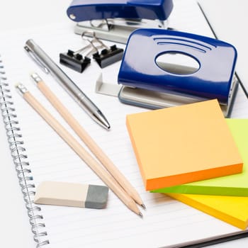 Variety of business office supplies on white notepad