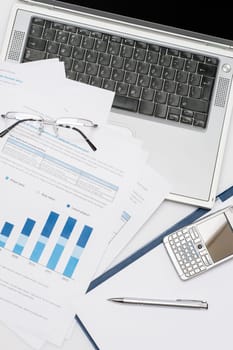 Business accessories stacked chart phone laptop lying office desk