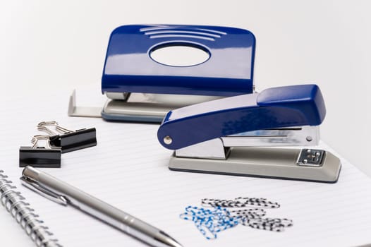 Variety of business office supplies on white notepad