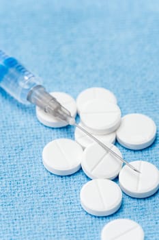 Injection needle with prescription pills blue background