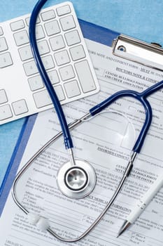Stethoscope laying over doctors emergency report medical documentation