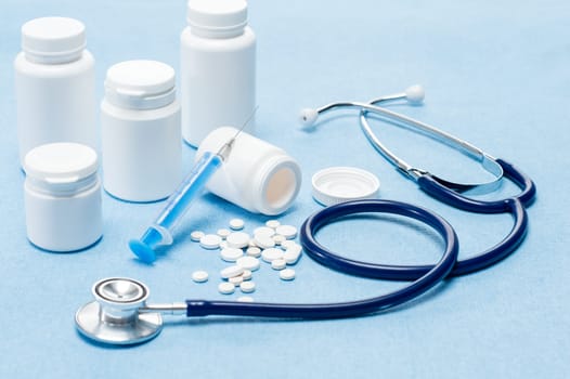 Medical supplies with spilled pills, injection and stethoscope
