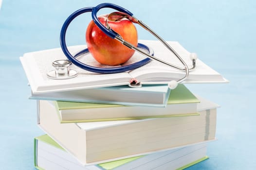 Medical books, apple and stethoscope healthy lifestyle medical research