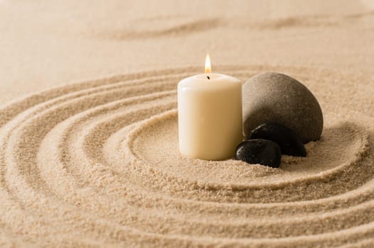 Spa atmosphere candle with zen stones in sand still nature