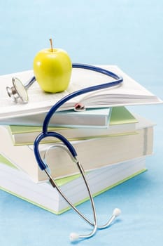 Medical books, apple and stethoscope healthy lifestyle medical research