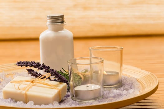 Aromatherapy lavender cosmetic products with candles on wooden tray