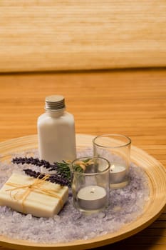 Aromatherapy lavender cosmetic products with candles on wooden tray