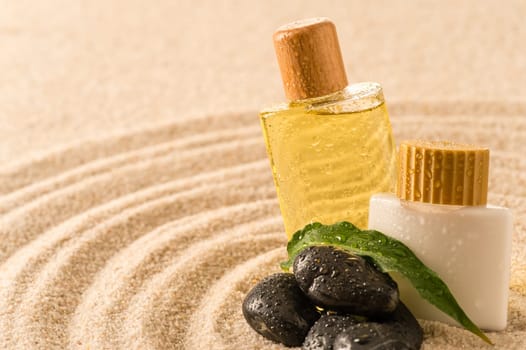 Spa therapy cosmetic products with zen stones on sand