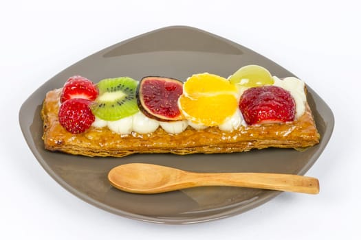 Pastry and cream dessert with strawberries, kiwi, grapes, figs