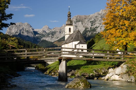 Church in Ramsau with stream and wooden bridge
