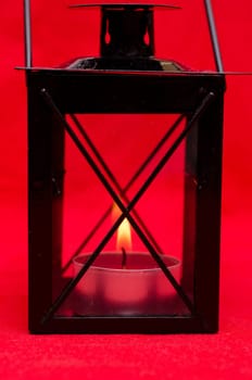 Burning candle in a black lantern