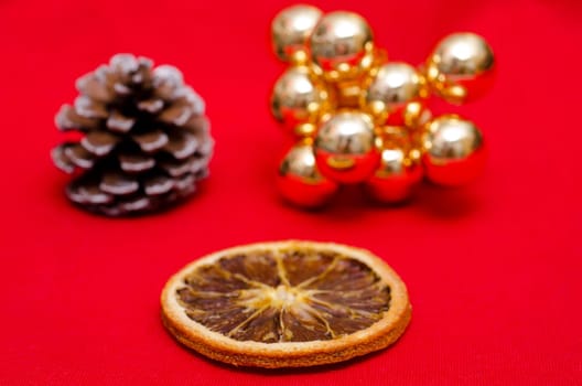 Dried orange slice and a pine cone and golden Christmas balls