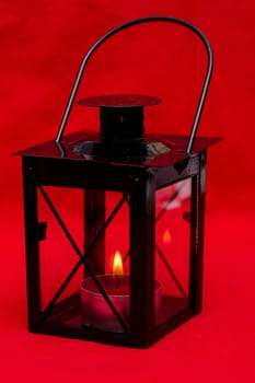 Black lantern in front of a red background