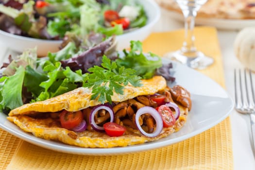 Omelet filled with chanterelle mushrooms and vegetable salad