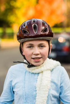 Young girl in fall wearing bicycle helmet