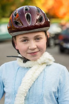 Young girl in fall wearing bicycle helmet