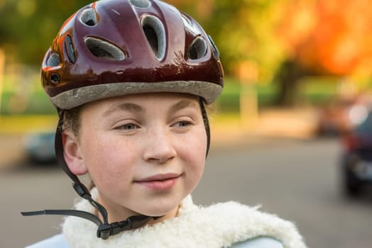 Young girl in fall wearing bicycle helmet