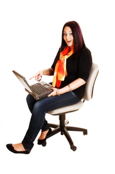A young woman, sitting on an office chair with a laptop on her lap and found some very interesting staff, for white background.