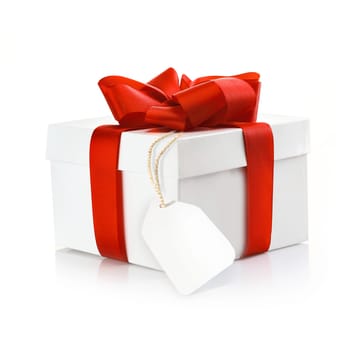 Christmas surprise gift with blank tag and a decorative red ribbon and bow on a white studio background