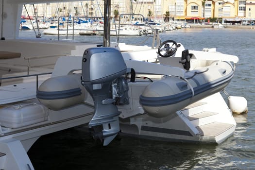 Dinghy with outboard engine on a catamaran sailing yacht in the port of Gruissan in the south of France