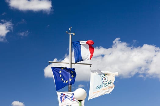 Flagpole in the port of Gruissan in front of blue sky