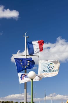 Flagpole in the port of Gruissan in front of blue sky