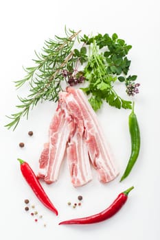 Raw spare ribs with rosemary on white background