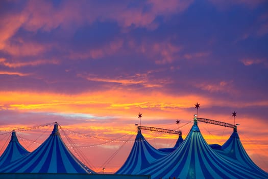 Circus tent in a dramatic sunset sky colorful orange blue with lights