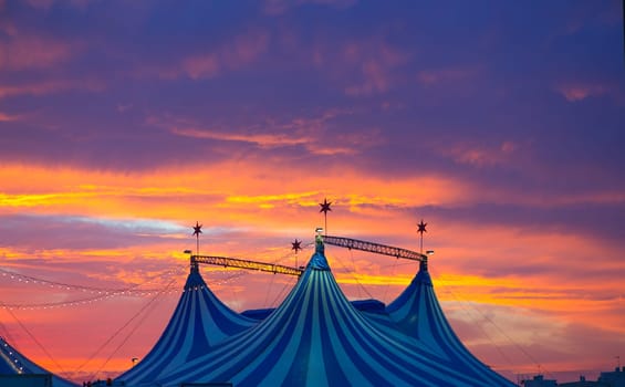 Circus tent in a dramatic sunset sky colorful orange blue with lights