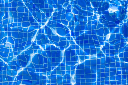 Blue tiles pool with ripple water reflection as a summer background