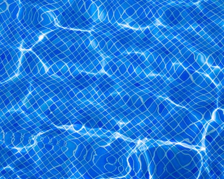 Blue tiles pool with ripple water reflection as a summer background